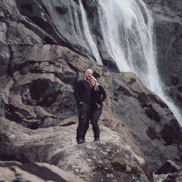 Couple standing on rocks in front of Aber Falls North Wales