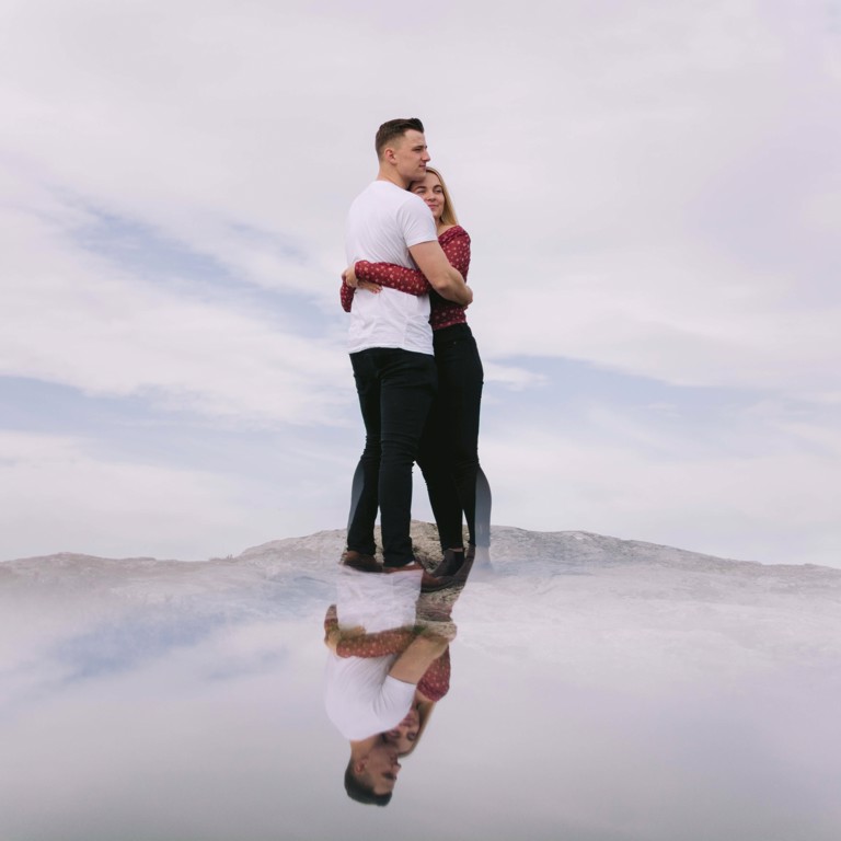 Reflection of couple standing on top of Hope Mountain North Wales