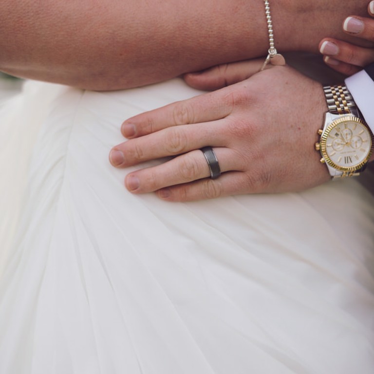 Close up photograph of grooms wedding ring on hand at Lion Quays