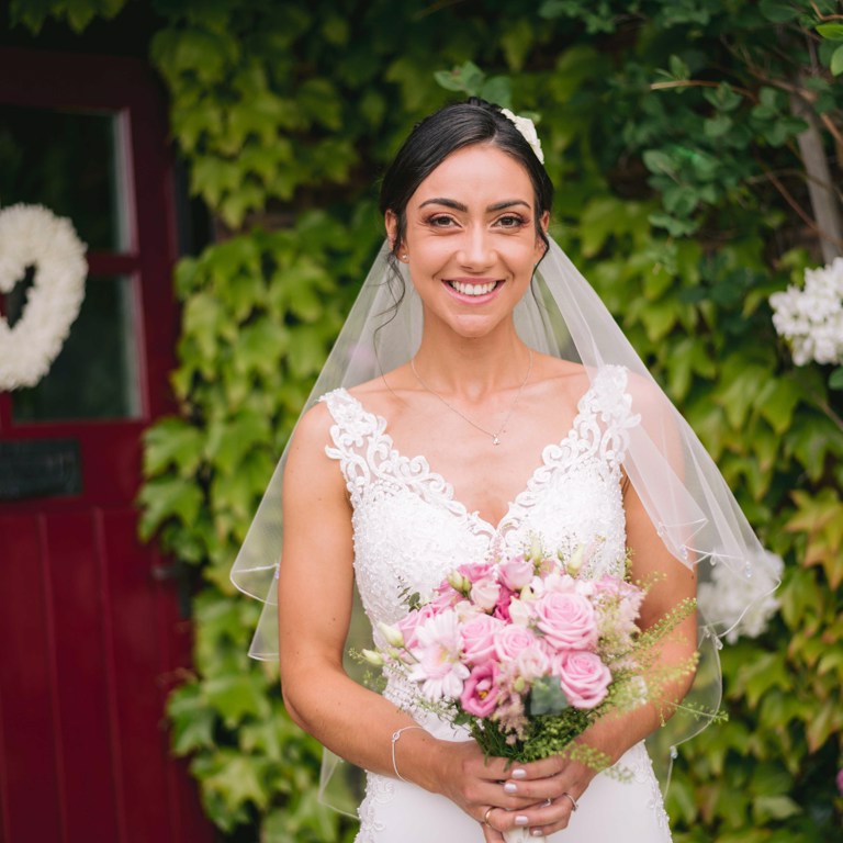 Bride outside entrance to home before Marquee wedding in Penyffordd North Wales