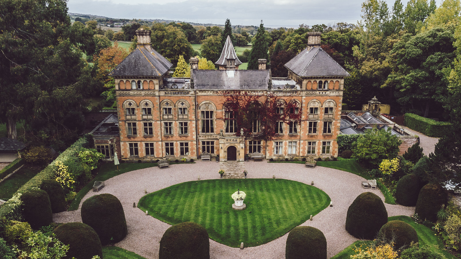 Arial view of Soughton Hall showcasing the architecture and manicured lawns during a wedding day