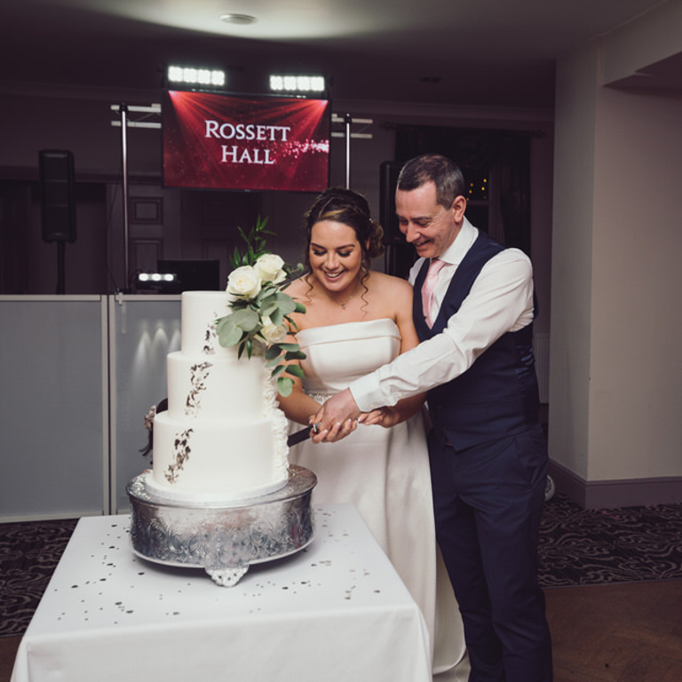 Bride & Groom cut cake on dancefloor at Rossett Hall