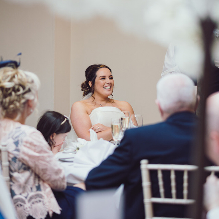 Bride laughs during speeches at Rossett Hall wedding