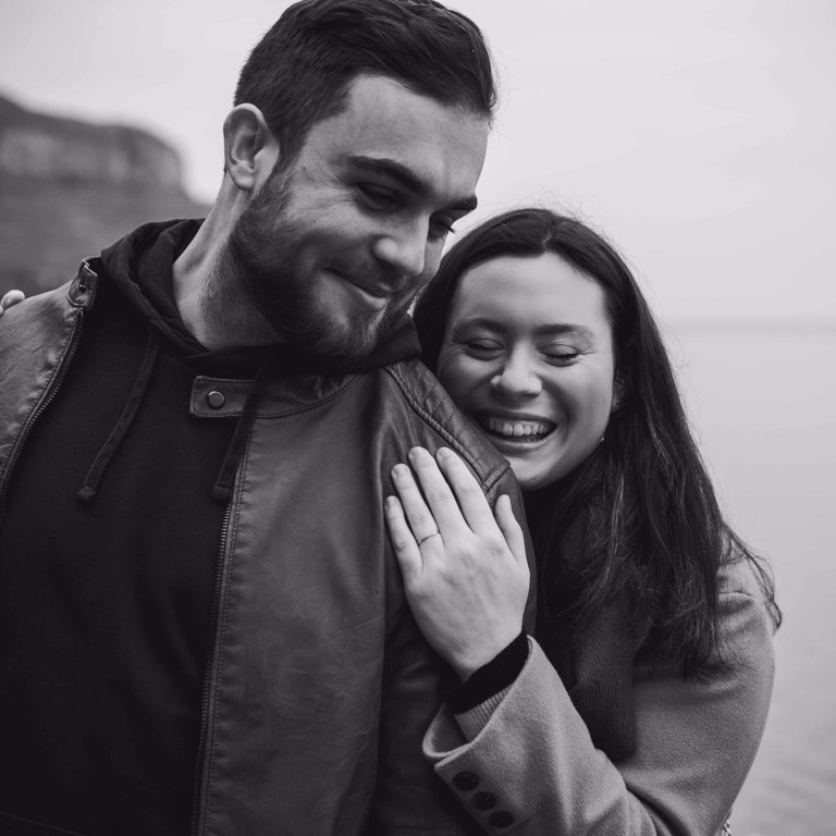 Engaged couple laugh during pre-wedding photoshoot
