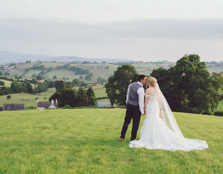 Bride & Groom kiss on top of hill with stunning views during a local wedding photography session