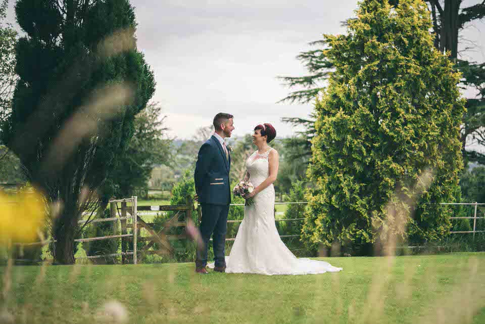 Bride & Groom laugh during wedding day portrait session in gardens at Highfield Hall