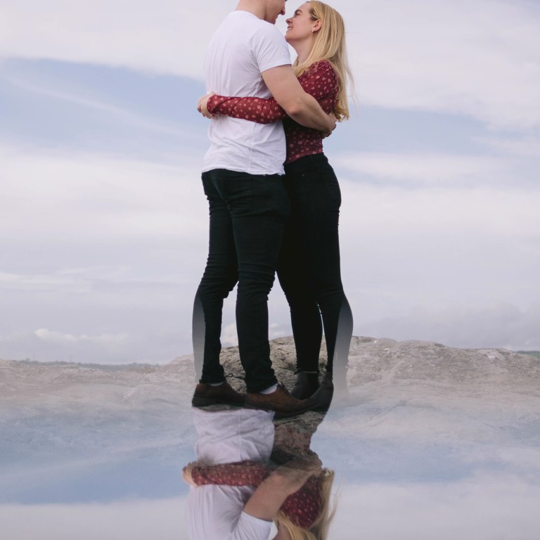 Reflection of couple standing on top of Hope Mountain North Wales