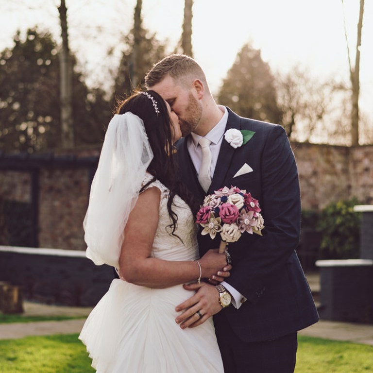 Bride & groom kiss outside Lion Quays in Oswestry during sunset