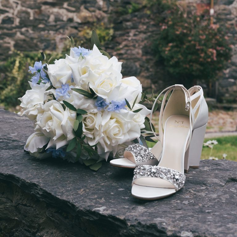 Brides shoes and flowers at wedding in North Wales