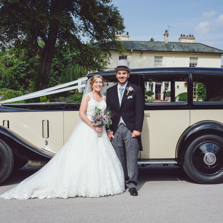 Bride & Groom laugh in front of classic car at Highfield Hall North Wales