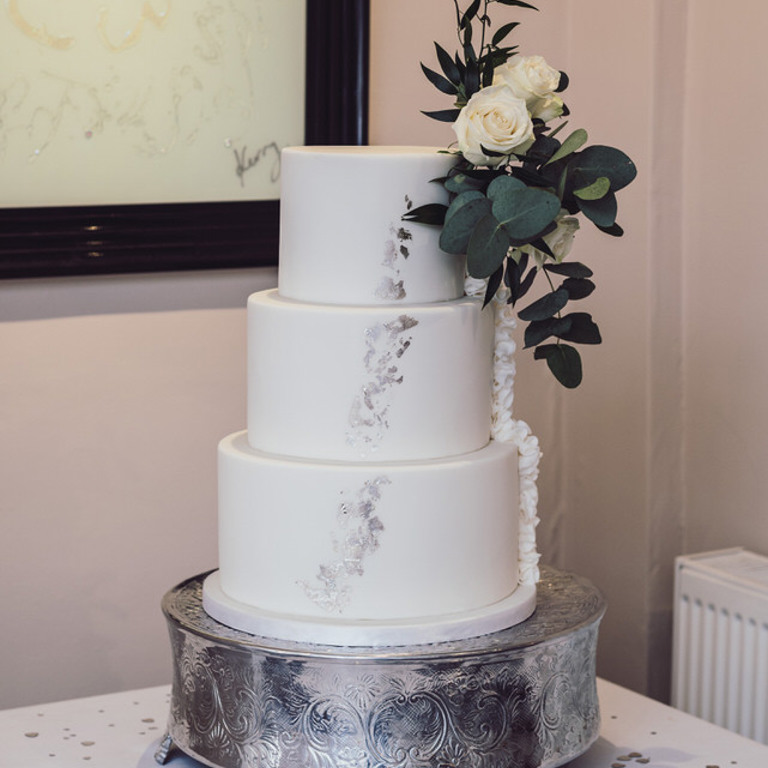 Wedding cake with roses on in function room at Rossett Hall