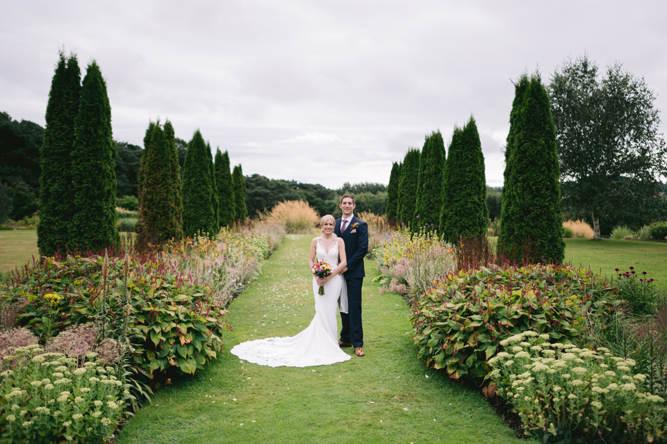 Bride & Groom stand in gardens at Abbeywood Estate wedding