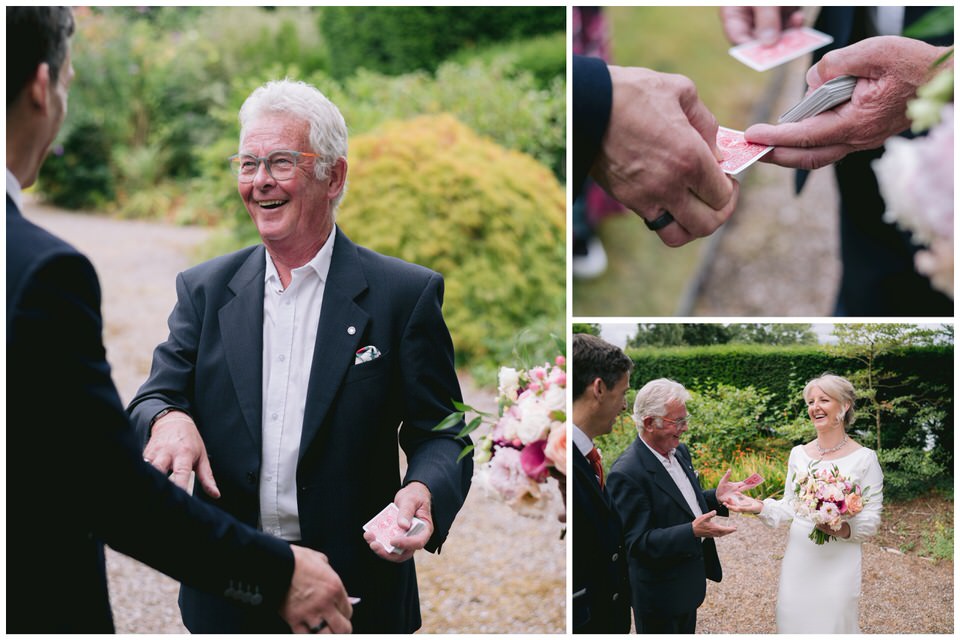 Magician smiles whilst doing card tricks for Bride & Groom at Château Rhianfa North Wales