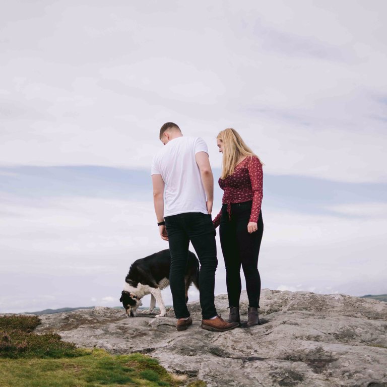 Dog walks past engaged couple during pre-wedding photoshoot