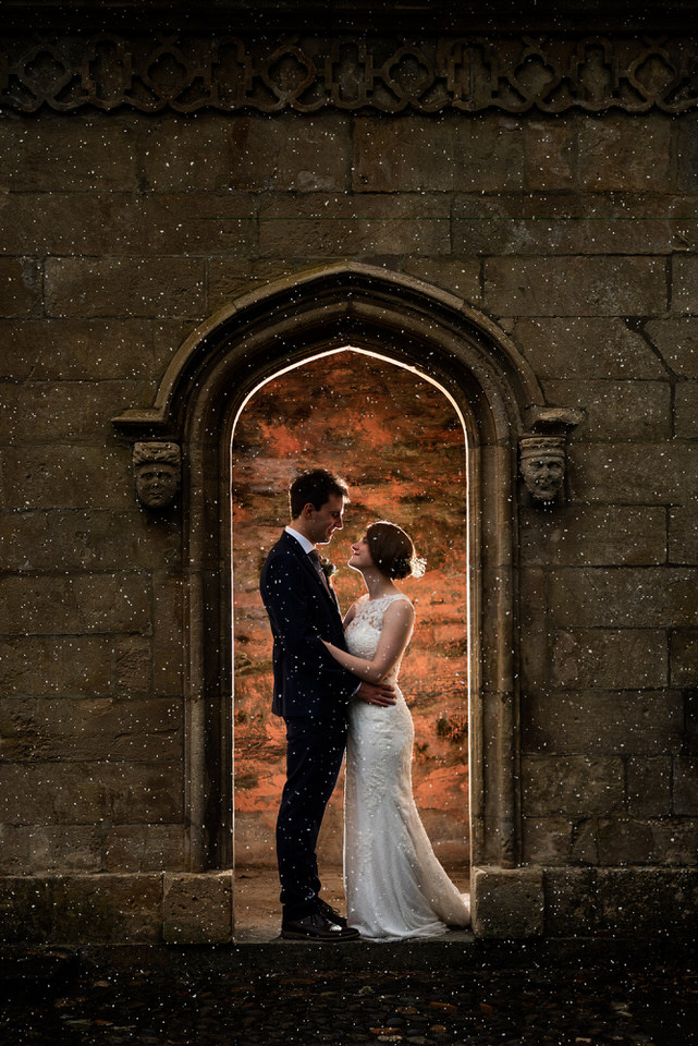 Bride & Groom look at each other in a backlit archway during North Wales wedding photography