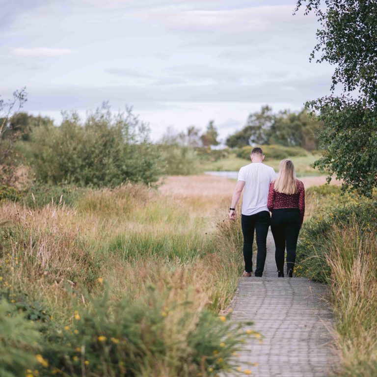 Engaged couple walk together in North Wales