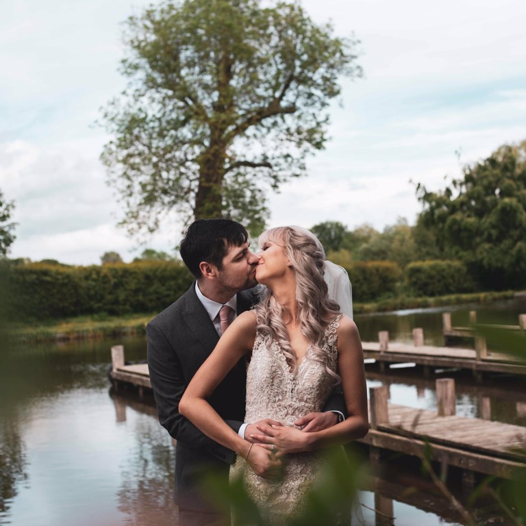 Bride & Groom kiss in front of canal at Lion Quays Oswestry 
