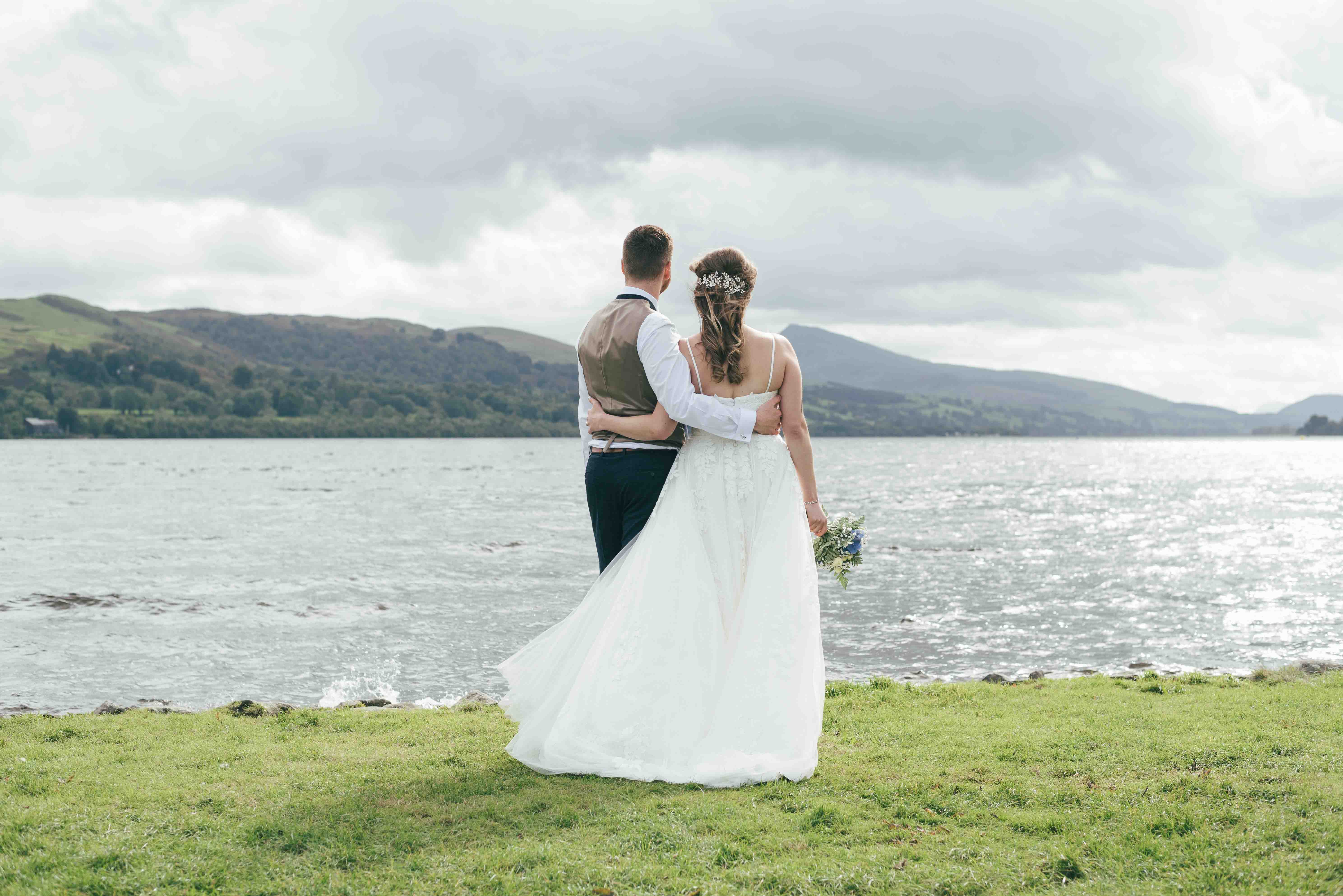 Bride and groom look out at Bala Lake in North Wales