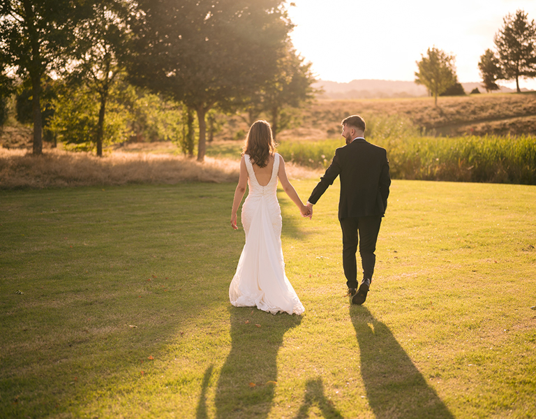 Bride and Groom walk away into the sunset outside Flint Mountain Park Hotel wedding in North Wales
