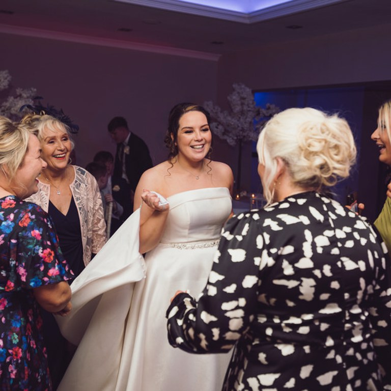 Bride dances with family & friends at Rossett Hall wedding venue