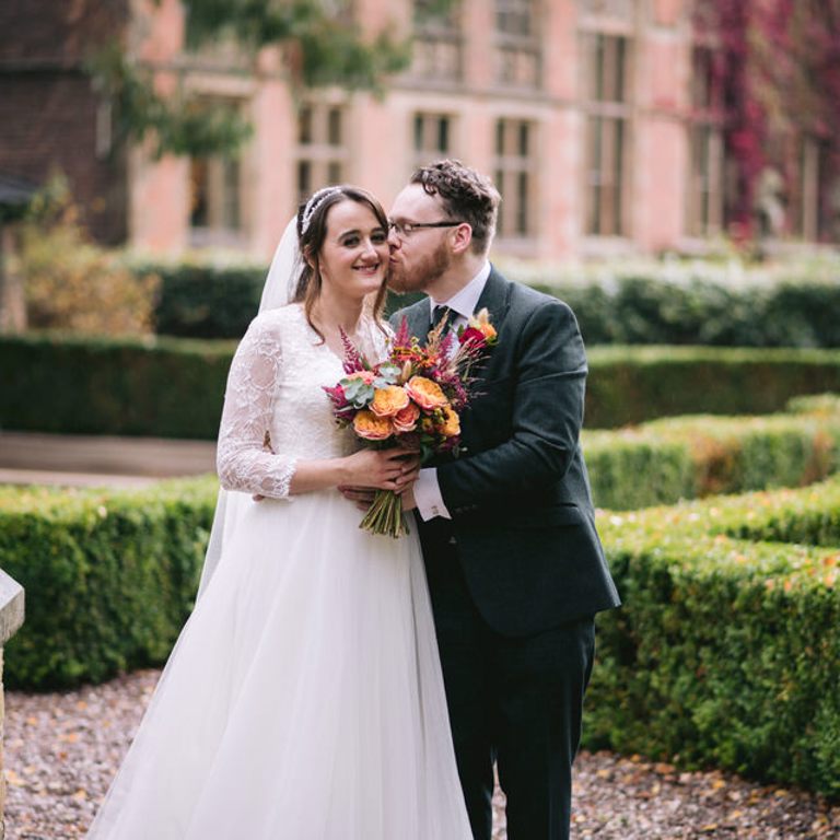 Groom kisses Bride in front of Soughton Hall North Wales Wedding