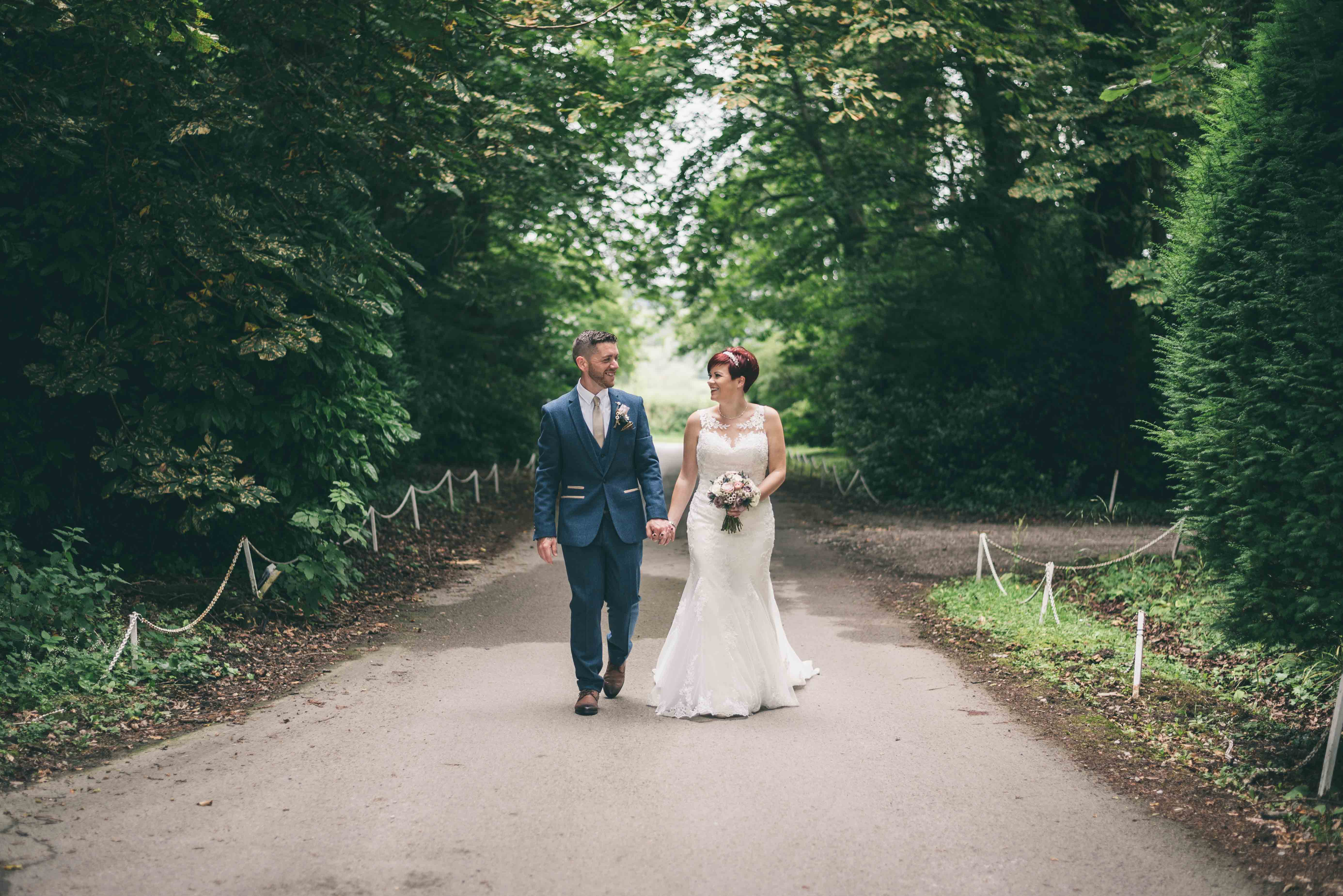 Bride & Groom walk up driveway and chat during wedding photography at Highfield Hall