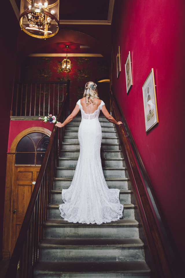 Bride on beautiful vintage staircase at Harrisons Hall during wedding photography