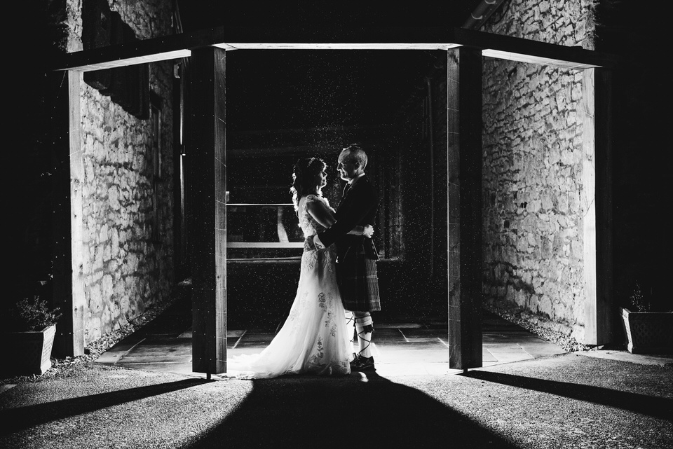 Bride & Groom backlit in archway during North Wales wedding photography at Faenol Fawr