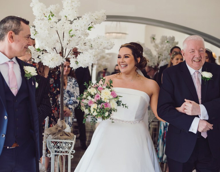 Bride smiles at groom during during ceremony photography at Rossett Hall