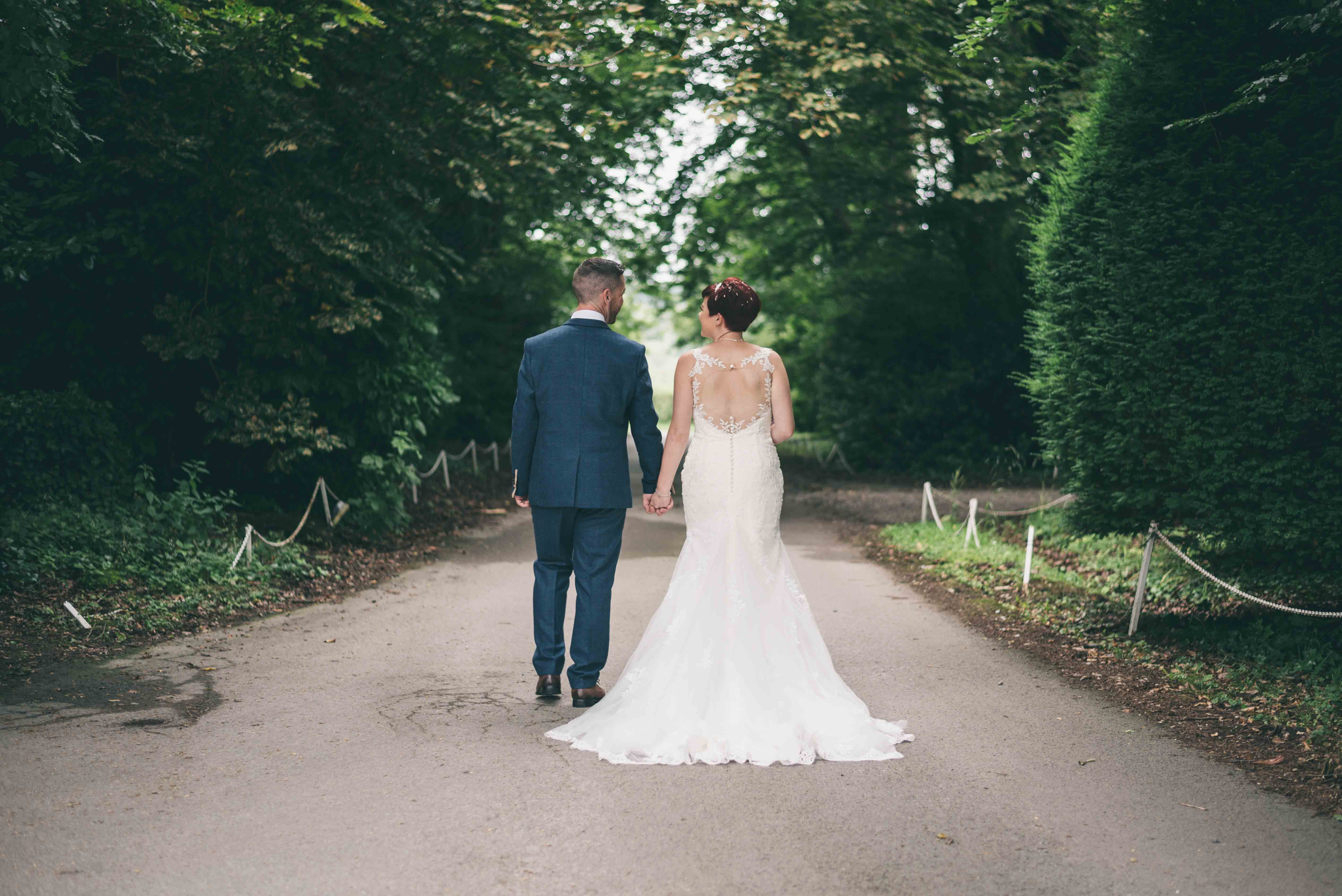 Bride & Groom walk up driveway and chat during wedding photography at Highfield Hall