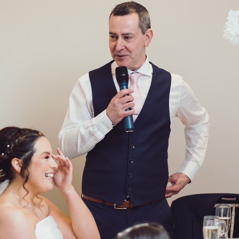 Groom makes speech and bride laughs during wedding at Rossett Hall