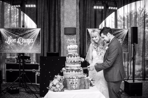 Bride & Groom cut the cake during wedding reception at Lion Quays
