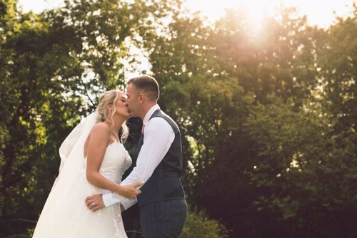 Bride & groom kiss at sunset during wedding at North Wales wedding venue