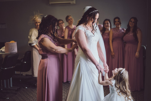 Bride looks at flower girl during prep at Lion Quays wedding