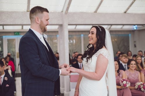 Bride & Groom hold hands during wedding ceremony at Lion Quays